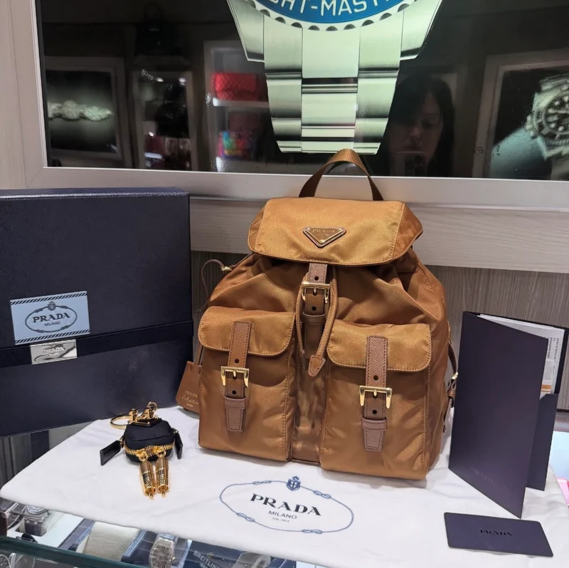 Zaino Prada Re-Edition 1978 Small Re-Nylon Brandy e ciondolo per borsa Robot mai indossati (2025)