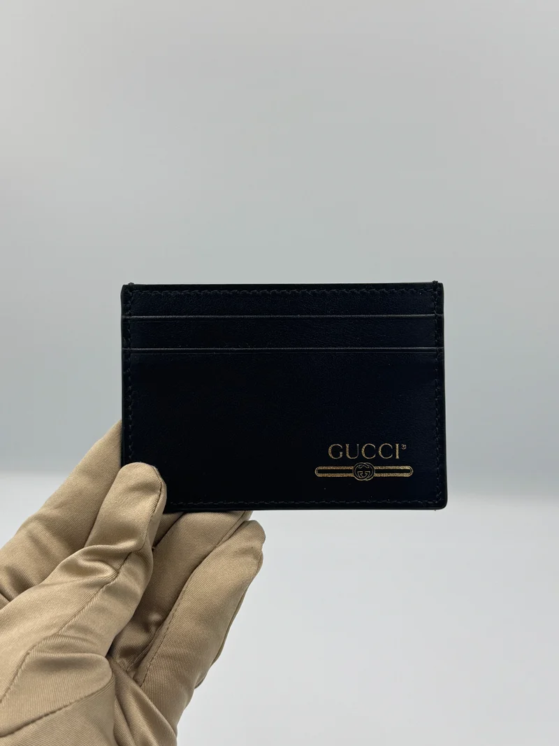 Portacarte Gucci nero liscio con logo mai indossato Stile: 547596